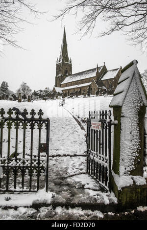 Gehen durch das Tor im Vorfeld zu einer Kirche mit einer Schneedecke den Pfad und die Kirche in der Ferne Stockfoto