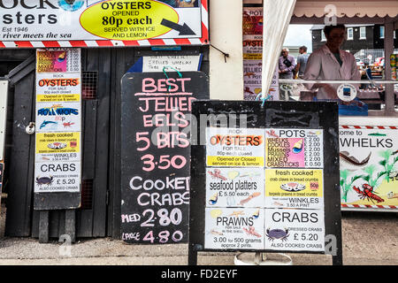 Anzeigetafeln Sie, die Preise der frisch gefangene Meeresfrüchte außerhalb einen Stall in der Kentish Küstenort Whitstable zeigen. Stockfoto