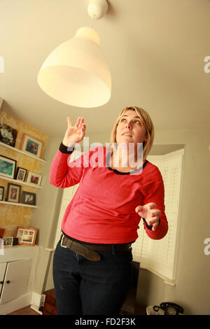 Frau wechseln einer Glühbirne Stockfoto