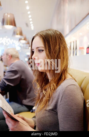 Junge Frau lesen Surfen Restaurant Speisekarte Stockfoto