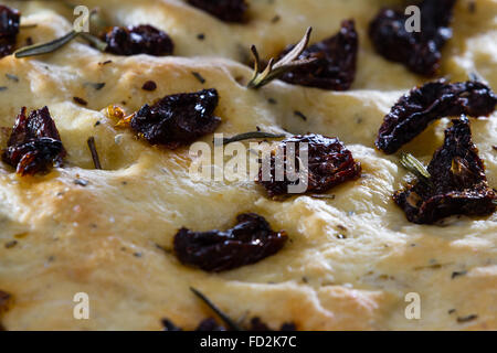 Nahaufnahme eines Roll-hausgemachte Focaccia mit getrockneten Tomaten und frischem Rosmarin Zweige an der Spitze Stockfoto
