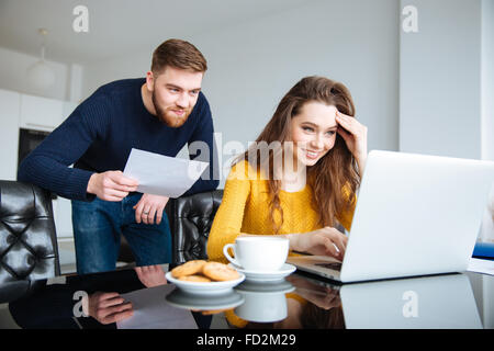 Porträt von ein glückliches junges Paar Berechnung Rechnungen zu Hause Stockfoto