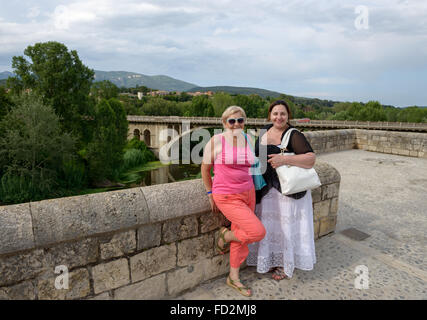 Porträt von Mutter und Tochter, die im Hintergrund alte Brücke der mittelalterlichen Stadt Besalú, Katalonien, Spanien darstellen werden. Stockfoto