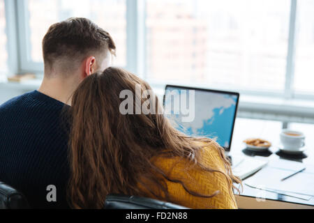 Rückansicht-Porträt eines Paares mit Laptop-Computer zu Hause Stockfoto