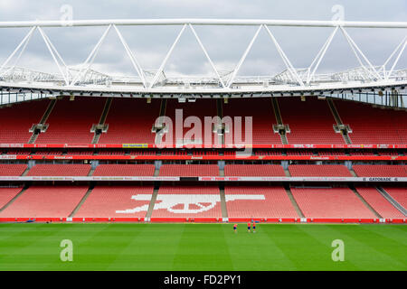 Sitze und Feld im Emirates Stadion, Heimat von Arsenal, mit dem Symbol der "Gunners" Stockfoto