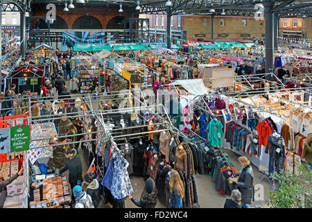 Schauen Sie auf die Leute, die an den Verkaufsständen des Old Historic Spitalfields Covered Market in London Borough of Tower Hamlets, England, einkaufen Stockfoto