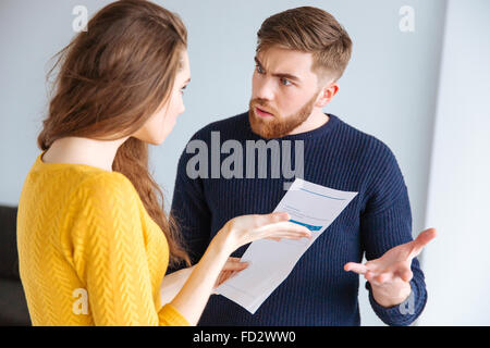 Porträt eines jungen Paares über inländischen Rechnungen zu Hause diskutiert Stockfoto