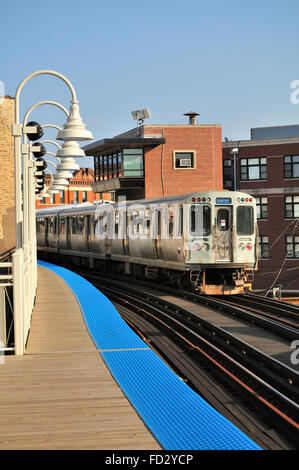 Ein CTA Blue Line Bahn verhandeln entlang einer erhöhten Struktur und in der Chicago Damen Avenue entfernt. Chicago, Illinois, USA. Stockfoto