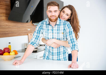 Porträt einer lächelnden jungen Paar umarmt in der Küche zu Hause Stockfoto