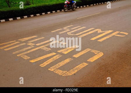 Road-Warnung auf die Boden-Warnung, die gibt es einen "Buckel voraus" in Bezug auf eine Bremsschwelle in Kigali, Ruanda, Afrika gemalt Stockfoto