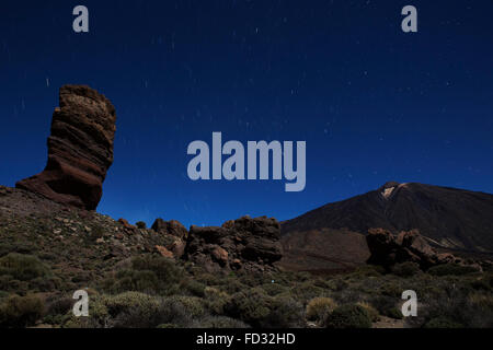 Sterne-Trail in den nächtlichen Himmel über Los Roques de Garcia und den Teide im Teide Nationalpark auf Teneriffa, Spanien. Stockfoto