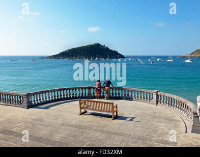 Älteres paar beobachten die Concha-Bucht und die Insel Santa Clara in Kontxa Pasalek. Donostia, San Sebastian, Baskenland. Spanien. Stockfoto