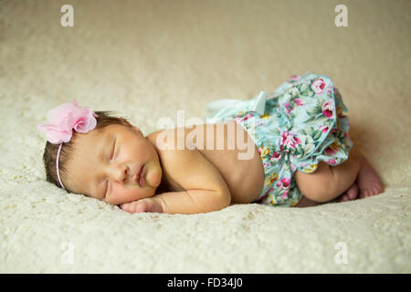 Neugeborenes Babymädchen schlafend auf einer Creme Decke Stockfoto