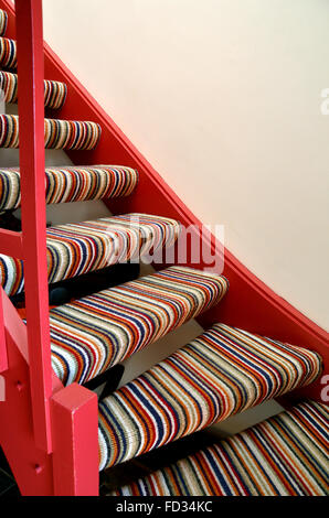Ein Abschnitt einer stripey Teppichboden einfache Treppe. Stockfoto