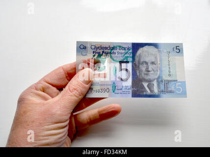 Eine neue Clydesdale Bank, 5-Pfund-Note in einer Hand gehalten und einen Abschnitt der Kunststoff transparent Natur offenbart. Stockfoto