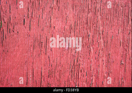 Eine verwitterte rot lackierten Holzoberfläche als Hintergrund Stockfoto