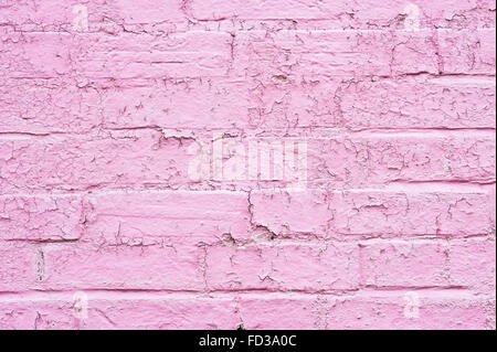 Abblätternde rosa Farbe auf eine Mauer als Hintergrund Stockfoto