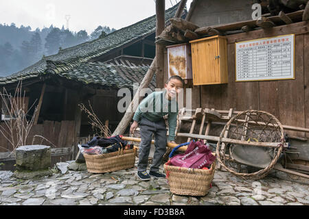 Lächelnde Miao-junge mit Bambus mit Pole und Körbe, Langde Shang Miao Dorf, Guizhou Provinz, China Stockfoto