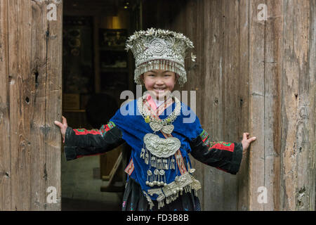 Langer Rock Miao Mädchen posiert in einer Tür, Langde Shang Miao Dorf, Guizhou Provinz, China Stockfoto