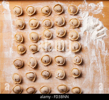 Rohes Fleisch Knödel russische traditionelle Pelmeni mit Fleisch auf hölzernen Hintergrund Stockfoto