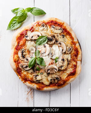 Pizza mit Pilzen und Basilikum auf weißem Holz Hintergrund Stockfoto