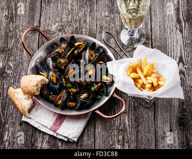 Muscheln, Pommes Frites und Wein auf hölzernen Hintergrund Stockfoto