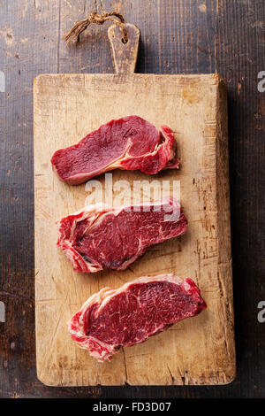 Rohes Frischfleisch Ribeye Steak auf Schneidebrett auf hölzernen Hintergrund Stockfoto