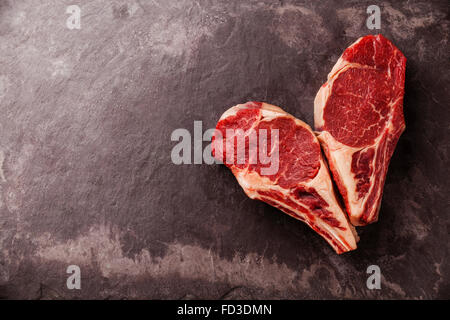 Herzform rohes Frischfleisch Ribeye Steak auf Knochen auf Stein Schiefer Hintergrund Stockfoto