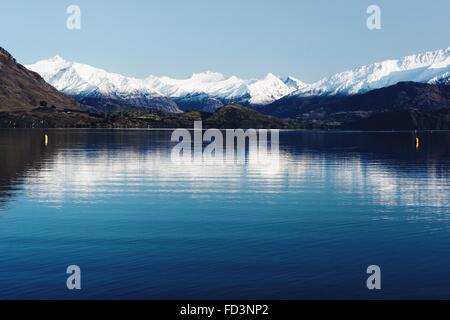 Schönen sonnigen Tag Reflexion über die blauen Lake Wanaka mit schneebedeckten Bergen im Hintergrund. Stockfoto