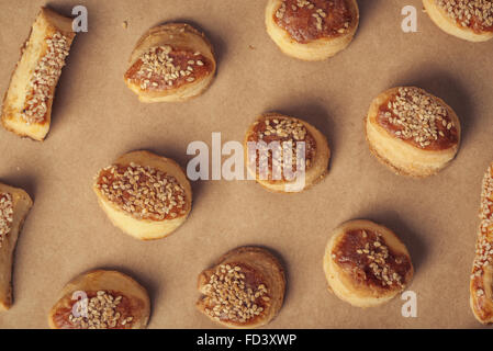 Draufsicht des frischen hausgemachten salzig Scones mit Käse und Sesam, schmackhafte Lebensmittel auf Kraftpapier, Backen über Kopf gedreht. Stockfoto