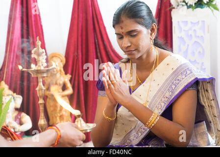 Frau Priester Gebete erhielt. Traditionelle indische Hindus Ohrlochstechen Zeremonie. Indien spezielle Rituale. Stockfoto