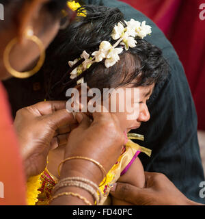 Traditionelle indisch-hinduistischen Familie Ohrlochstechen Zeremonie für Babymädchen in ein Jahr alt. Stockfoto