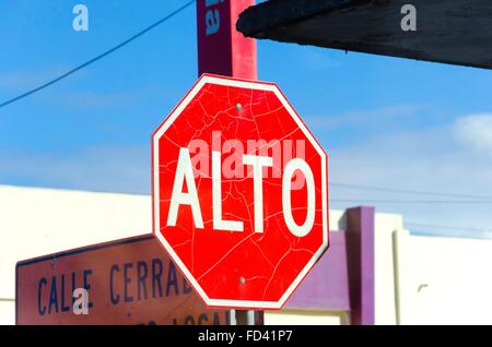 Eine alte, rissige, grungy Straßenschild mit der Aufschrift "Alto", d.h. Halt in Spanisch, gedreht in den Straßen von Tijuana in Mexiko. Stockfoto