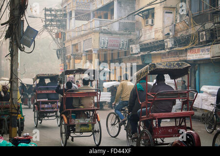 Fahrrad-Rikschas (Tuk-Tuks) an viel befahrenen Straße im Winter in Delhi Stockfoto