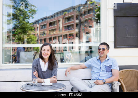 Freunden Kaffee am Morgen auf der Terrasse im Zentrum von Amsterdam herzlich lachen Stockfoto