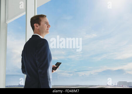Kaukasische Geschäftsmann mit Telefon im modernen Büro Stockfoto