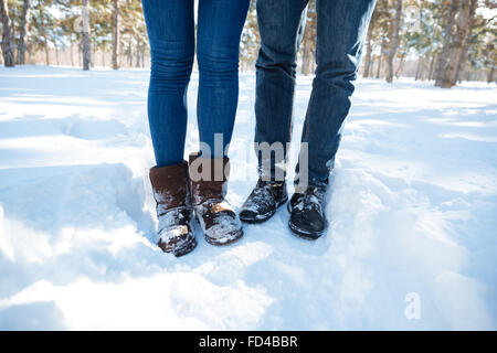 Closeup Portrait von männlichen und weiblichen Beine in Jeans stehen in Winter park Stockfoto