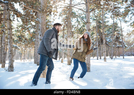 Fröhliches junges Paar im Winter park Stockfoto