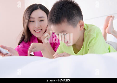 Mutter und Sohn mit digital-Tablette im Bett Stockfoto