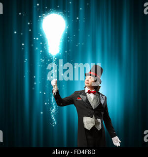 Bild Mann Magier zeigt Trick vor Hintergrund Farbe Stockfoto