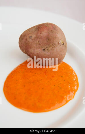Kartoffeln (Papas Arrugadas) und Mojo Rojo serviert in Teneriffa, Spanien. Die Speisen sind alle traditionelle kanarische Küche. Stockfoto