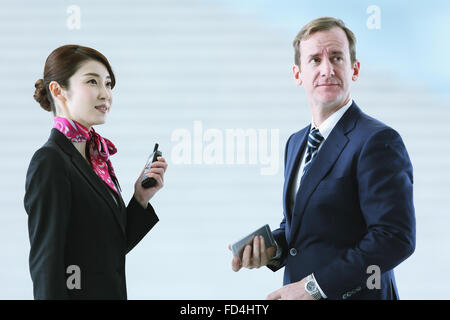 Japanische attraktive Stewardess helfen Kunden am Flughafen Stockfoto