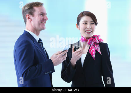 Japanische attraktive Stewardess helfen Kunden am Flughafen Stockfoto