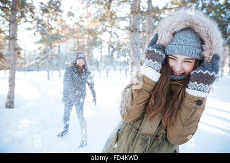 Glückliches junges Paar im Winter Kleidung spielen Schneebälle im freien Stockfoto