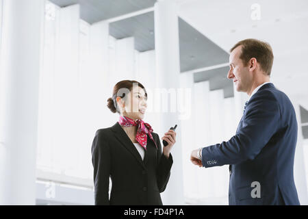 Japanische attraktive Stewardess helfen Kunden am Flughafen Stockfoto