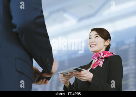 Japanische attraktive Stewardess helfen Kunden am Flughafen Stockfoto