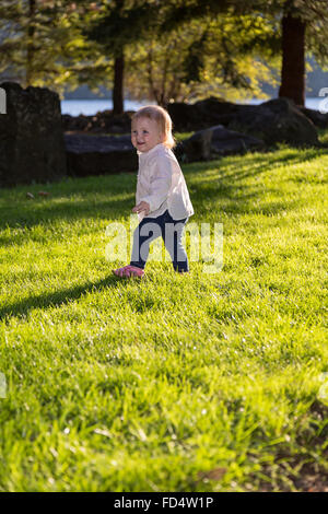 Glücklich Kleinkind im Park spielen auf der Wiese Stockfoto