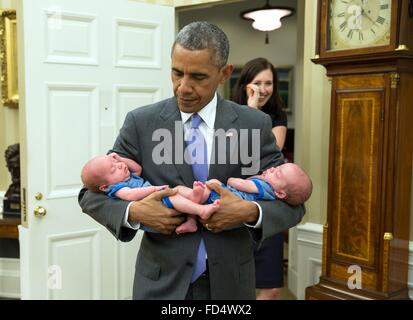 US-Präsident Barack Obama trägt die Zwillingen von Katie Beirne Fallon, Director of Legislative Affairs in das Oval Office nur wenige Monate nachdem sie 17. Juni 2015 in Washington, DC geboren wurden. Stockfoto