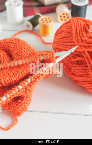 Eine Jacke oder einen Pullover mit Nadeln und Kugeln aus Wolle stricken Stockfoto