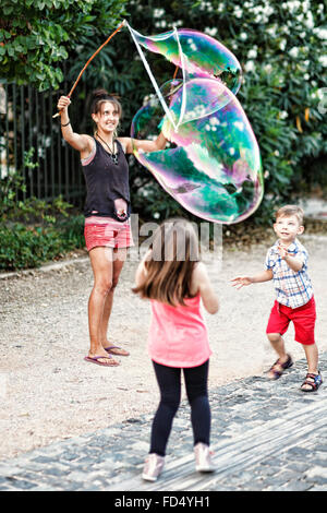 Kleine Kinder spielen mit riesige Seifenblasen in den Straßen von Athen, Griechenland Stockfoto